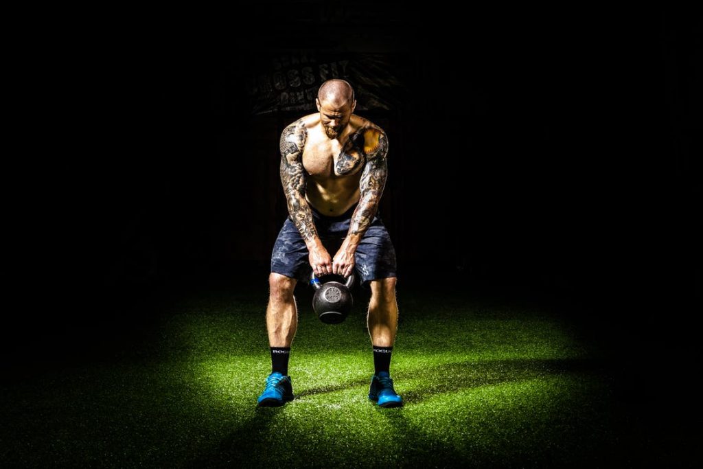 Man voert kettlebell oefening uit om af te vallen en kracht op te bouwen met correcte techniek
